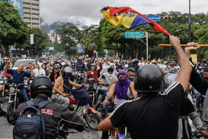 Opositores al gobierno de Nicolás Maduro recorren las calles en motocicletas.