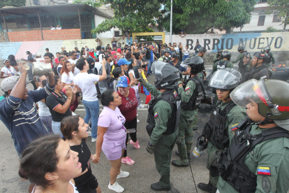 Personas reclaman frente a integrantes de la Guardia Nacional Bolivariana (GNB) durante una manifestación luego de los resultados de las elecciones presidenciales este lunes, en el sector del Primero de Mayo en Caracas (Venezuela).