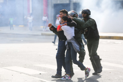 Integrantes de la Guardia Nacional detienen a personas durante una protesta por los resultados de las elecciones presidenciales este lunes, en Caracas (Venezuela).