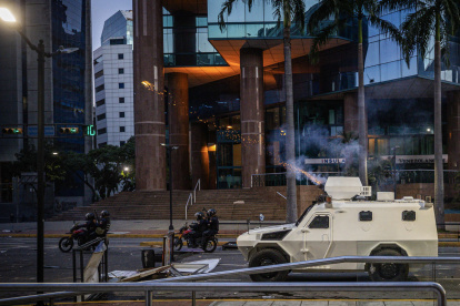 Integrantes de la Guardia Nacional Bolivariana (GNB) se enfrentan a manifestantes por los resultados de las elecciones presidenciales este lunes, en Caracas (Venezuela).