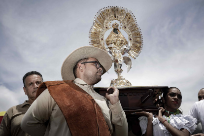 Varias personas participan durante la tradicional romería anual para mostrar su devoción, agradecer milagros y pedir favores a la Virgen de los Ángeles.