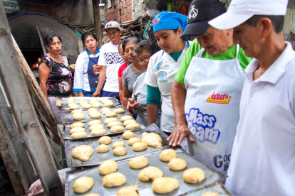 El septuagenario Jorge Tubay explica como debe quedar la masa para el pan.