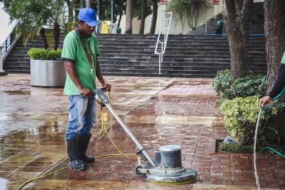 Trabajador realiza limpieza en el área turística.