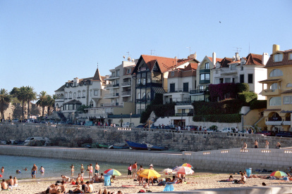 Los bañistas aparecen en la playa de la Ribera en la bahía de los pescadores de Cascais.