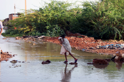 Una persona intenta atravesar una zona rural inundada en este país africano.