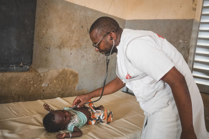 El doctor Baricomo Karambé, médico clínico, se encuentra en medio de una consulta con un niño desplazado.