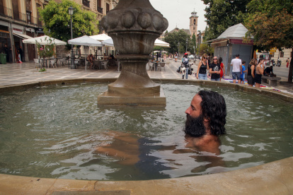 Granada. Un hombre se refresca en una fuente de la Plaza Nueva.