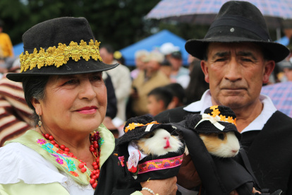 Una pareja sosteniendo dos cuy disfrazados de campesinos en Urbina (Ecuador), participando en el cuarto Festival del Cuy de Ecuador, una fiesta en torno al roedor más emblemático de los Andes.