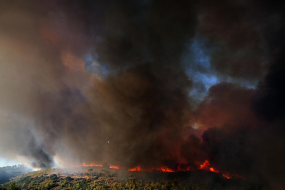 Un humo espeso se eleva durante un incendio forestal que estalló en una zona de tierras de cultivo y bosques en Varnavas, región de Ática, Grecia, el 11 de agosto de 2024.