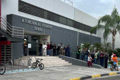 Trámite.- Los agentes de aduana muestran con una foto la larga fila que hay en el servicio al cliente en la oficina de Senae de Guayaquil.