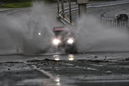 Un auto circula por una calle inundada por el paso del huracán Ernesto este miércoles, en San Juan, Puerto Rico.
