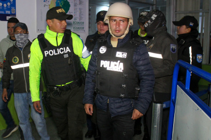 El presunto guerrillero Edgar Moncada Acevedo (d) es escoltado por integrantes de la Policía ecuatoriana.