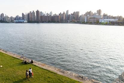 Nueva York. Inmigrantes a la orilla del Harlem River frente a Manhattan.