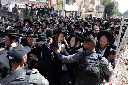 La policía intenta dispersar a judíos ultraortodoxos durante una protesta contra la ley de reclutamiento militar frente a la oficina de reclutamiento en Jerusalén.