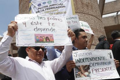 Trabajadores del Poder Judicial que sostienen carteles durante una protesta en contra de la reforma judicial impulsada por el oficialismo, en Ciudad de México (México).
