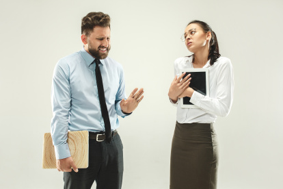 Angry boss. Man and his secretary standing at office or studio. Business man with his colleague. Female and male caucasian models. Office relationships concept, Human emotions
