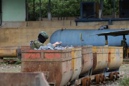 Un militar custodio carga de material mineralizado, en Camilo Ponce Enríquez, Azuay.