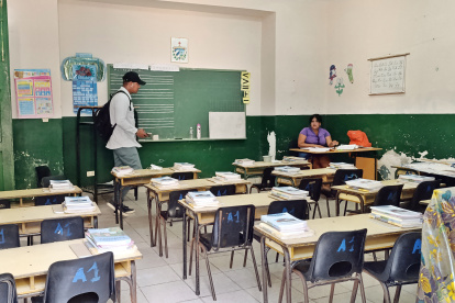 Una profesora prepara clase en el salón de una escuela previo al inicio de clases
