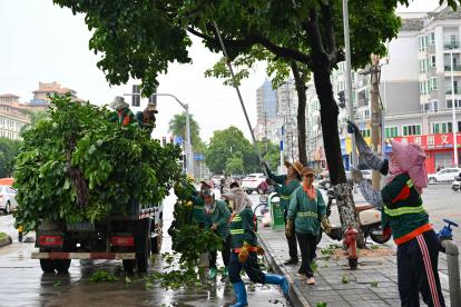 Prevención. Trabajadores cortan exceso de ramas en preparación a la llegada del tifón en la provincia de Hainan.