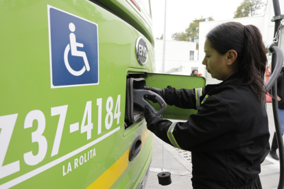 María Camila Escobar, técnica de mantenimiento, cargando un bus eléctrico en Bogotá.