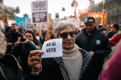 Una mujer que sostiene un cartel en una manifestación de jubilados el 28 de agosto de 2024