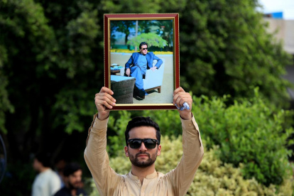 Un partidario del partido Pakistan Tehreek-e-Insaf (PTI) sostiene un retrato del fundador del partido y ex primer ministro Imran Khan.