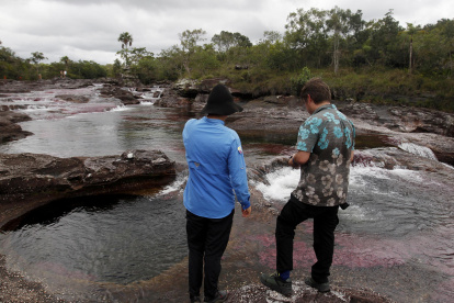 Dos personas observan el río Caño Cristales, también llamado el "río de los siete colores", en zona rural de La Macarena, departamento del Meta (Colombia).