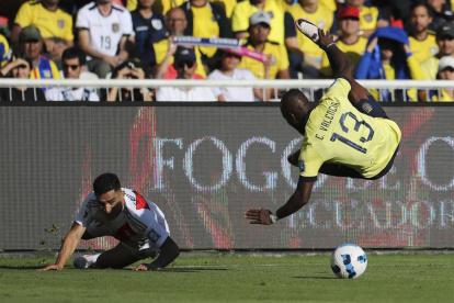 Enner Valencia (d) de Ecuador disputa un balón con Marcos López de Perú este martes.