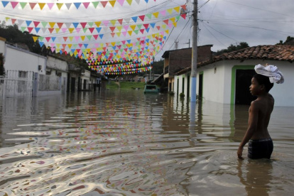 Archivo. Un niño camina por una calle inundada en Cali como consecuencia del fenómeno climatológico de "La Niña".