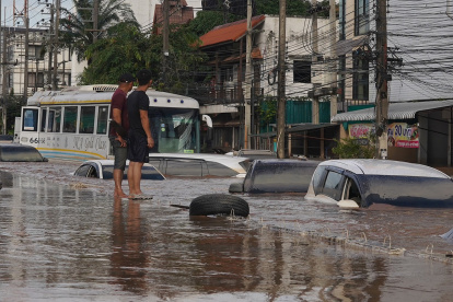 Hombres tailandeses observan una calle inundada tras fuertes lluvias en zonas urbanas de la provincia de Chiang Rai, al norte de Tailandia, el 12 de septiembre de 2024.