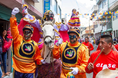 La Mama Negra viste de vistosos colores y está acompañada por los negros loeros.