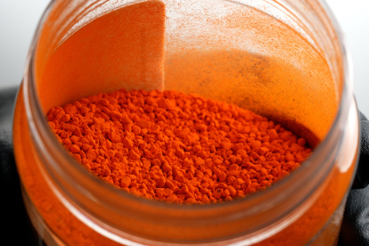 Primer plano de una mano enguantada sacando colorante FD & C Yellow 5 sin disolver de un tarro de cristal. Crédito: Matthew Christiansen/Fundación Nacional de la Ciencia de EE.UU.