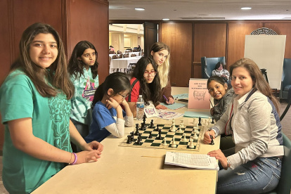 Martha Fierro (der) haciendo lo que más le gusta, enseñando ajedrez.