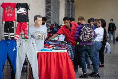 Un vendedor atienda clientes en su puesto de ropa, en Caracas (Venezuela).