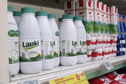 Botellas de leche en envases de plástico en un supermercado