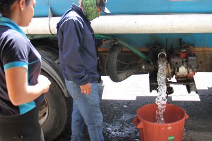 Las personas reciben agua en tanqueros, debido a los cortes de servicio en algunos barrios de Quito.