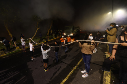 Vecinos de la avenida González Suárez y Manuel Barreto apoyan a las tareas de los bomberos para apaciguar el incendio en el sector, la noche de este martes 24 de septiembre.