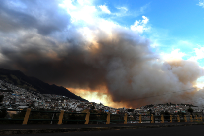 Fotografía de una columna de humo por un incendio forestal este martes, en el sector de Guapulo en Quito (Ecuador).