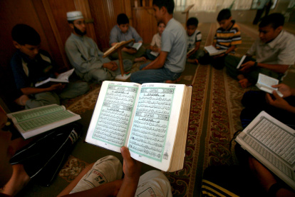 Gaza. Un grupo de niños palestinos se reúnen en algún lugar de la Franja para leer los versos del Coran ante la imposibilidad de asistir a clases.