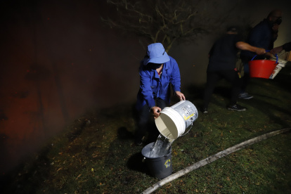 Intentos. Los quiteños hacen lo imposible para poder aplacar los focos de incendios cerca de sus casas.