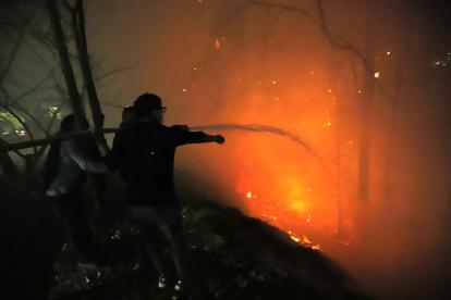 1. Guápulo. Con mangueras y baldes de agua, moradores de la zona ayudaban a los bomberos para evitar que el fuego llegue hasta las viviendas.