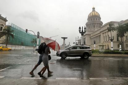 Dos personas caminan bajo la lluvia en la Habana.
