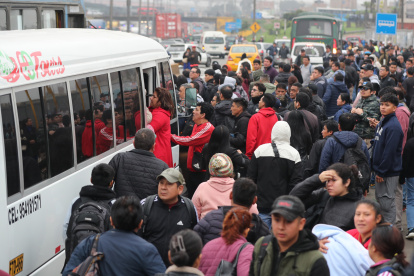 Decenas de personas intentan abordar un autobús durante una jornada de paralización