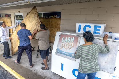 La gente cubre las ventanas con madera contrachapada mientras la ciudad se prepara para el huracán Helene en Mayo, Florida, EE. UU., 26 de septiembre de 2024.