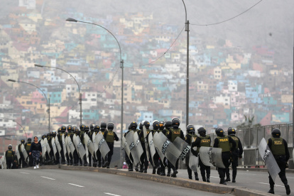 Policías resguardan una vía durante una manifestación de transportistas este jueves en Lima (Perú).