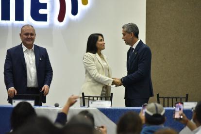 Luisa González y Raúl Chávez estrechándose la mano.