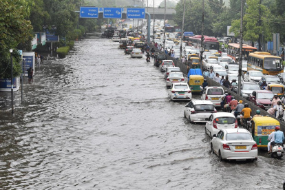 Un atasco en medio de una vía inundada a causa de fuertes precipitaciones