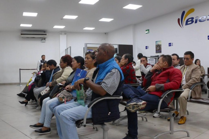 Clientes esperan en una sala del BIESS para atención al cliente.