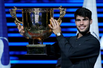 El español Carlos Alcaraz celebra con el trofeo tras vencer en la final del Open de China de Tenis al italiano Jannik Sinner.