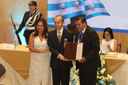 Agustín Febres-Cordero recibe su reconocimiento por parte del asambleísta José Luis Chamba. Los acompaña Alexandra Castillo.